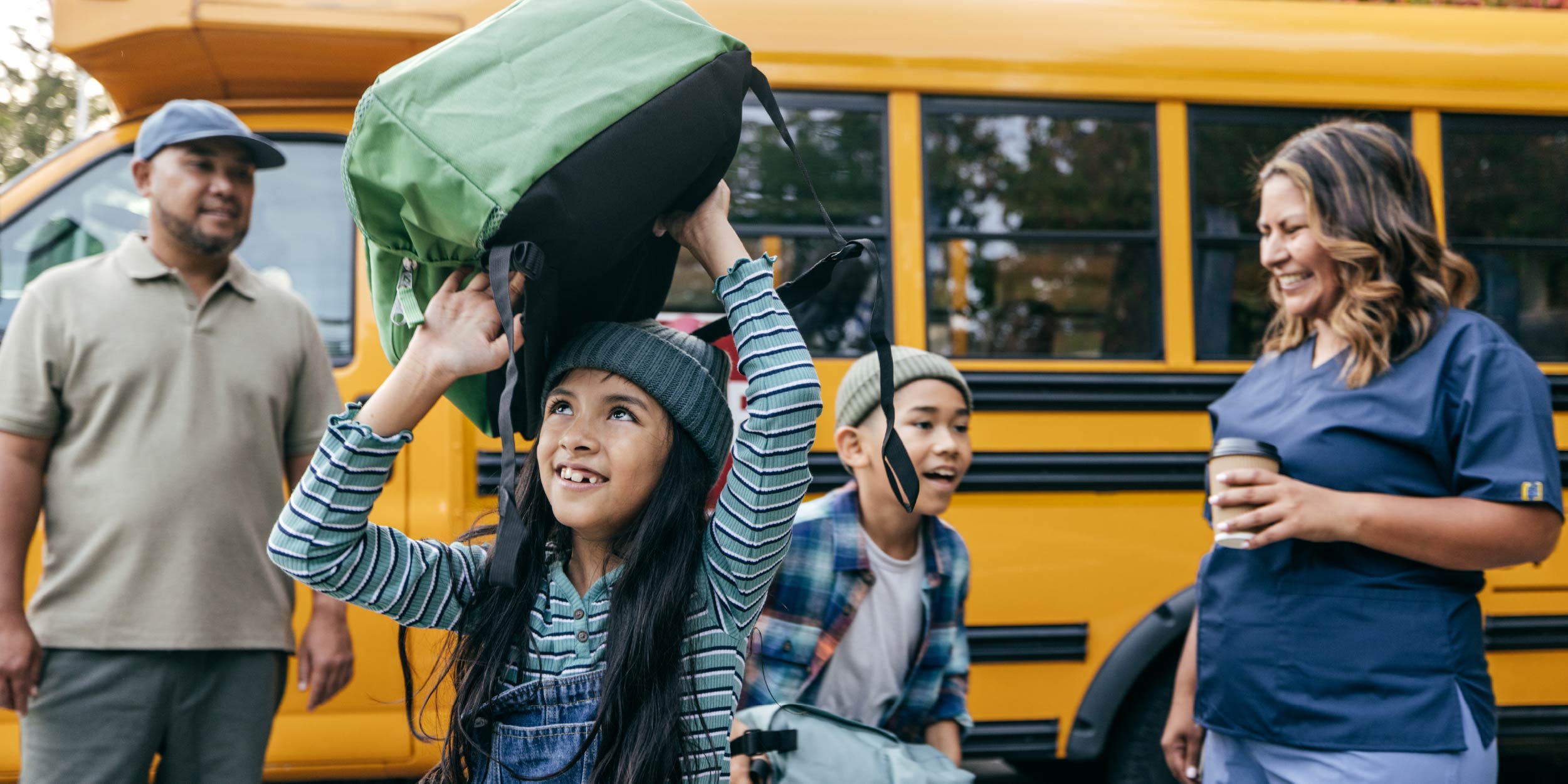 A latino family picking up their kids from the school bus