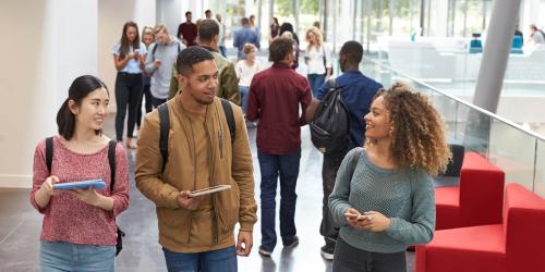 A group of community college students walking through the hall