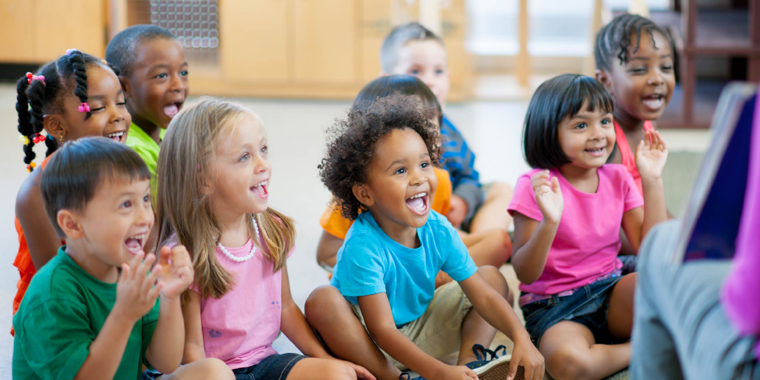 A group of preschoolers laughing and smiling